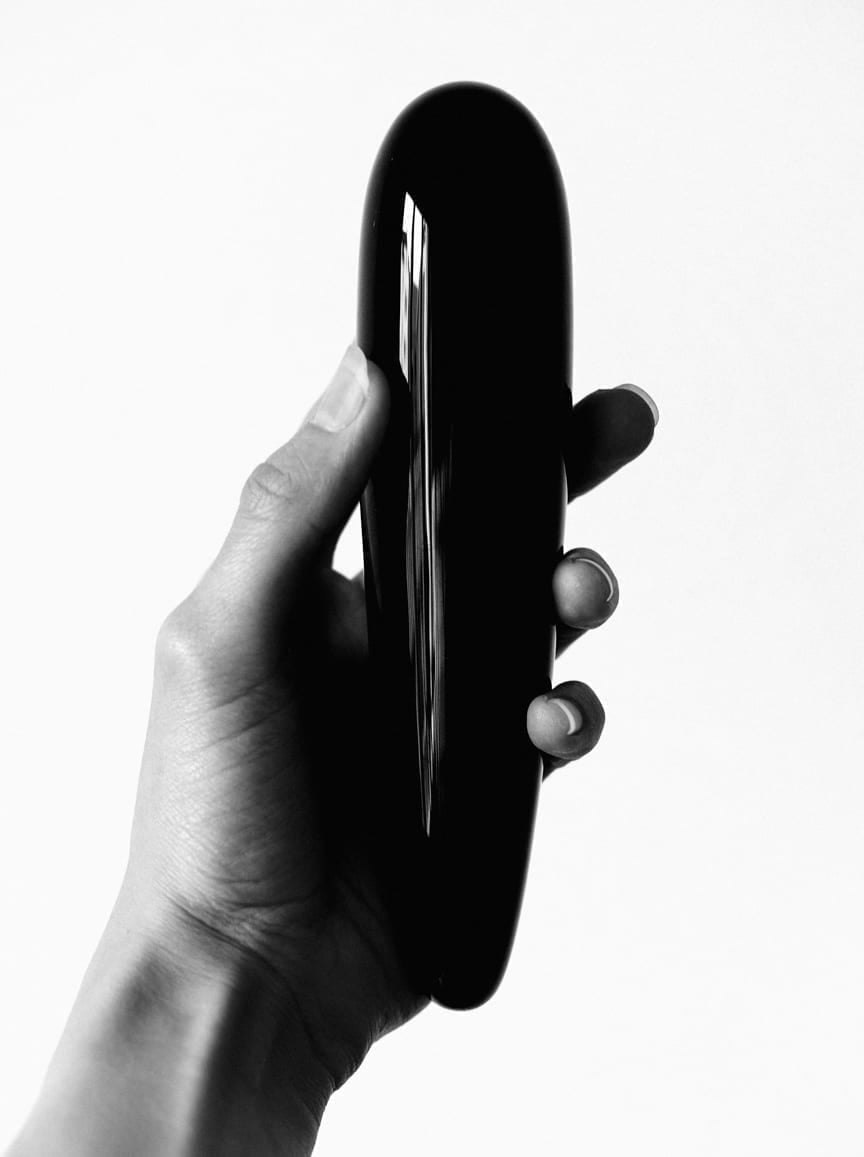 Yoni Wand aus Obsidian in der Hand einer Frau